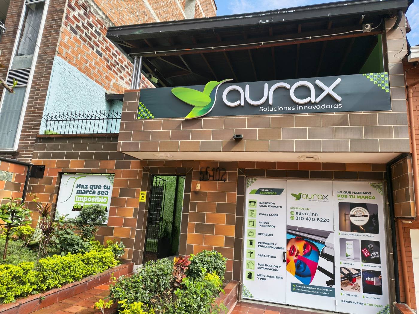 Fachada de la sede de Aurax Soluciones Innovadoras con su aviso de letras 3D y la vitrina de servicios