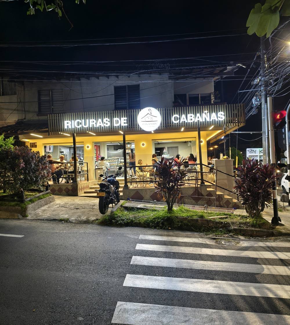 Fachada de Ricuras de Cabañas de noche con letras luminosas hechas por Aurax